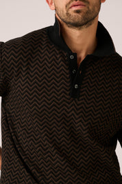 Man wearing a black and brown chevron patterned shirt against a plain background