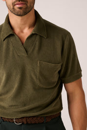 Man wearing a green polo shirt with a plain background