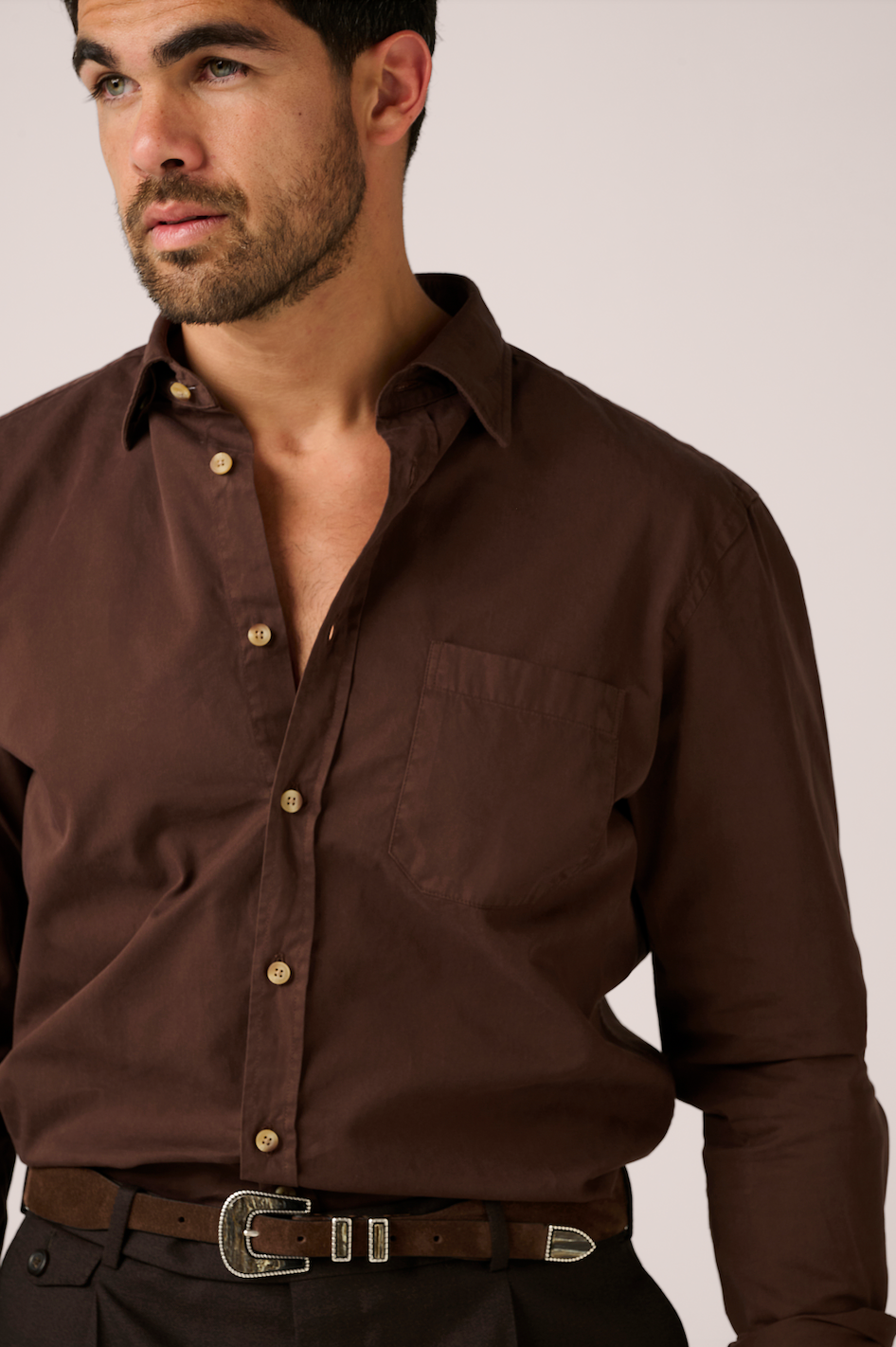 Man wearing a brown shirt with a plain background