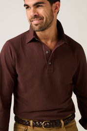 Man wearing a brown long-sleeve polo shirt against a plain background