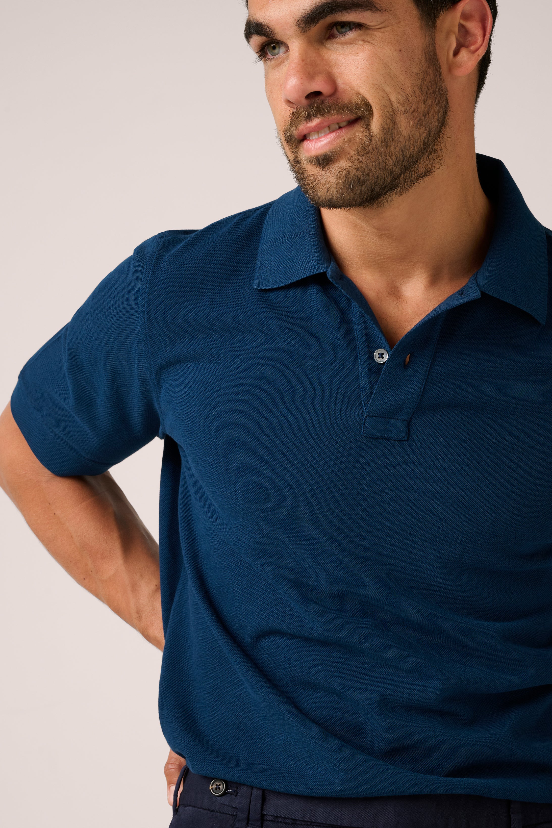 Man wearing a blue polo shirt against a plain background